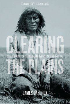 An Indigenous person sitting on the grass with the book title 